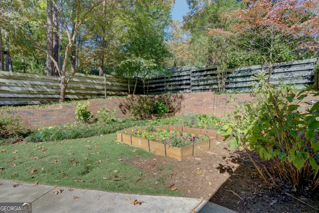 a view of backyard with seating space and trees in the background