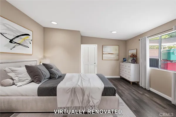 a bedroom with a bed painting on wall and a large window