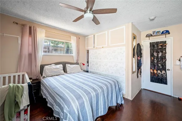 a bedroom with bed and wooden floor