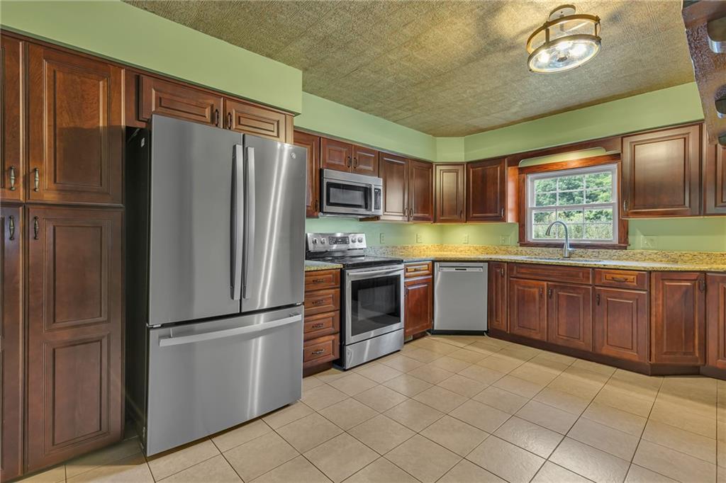 188 Logtown Road Darlington, PA 16115 - Photo 2 of 36 a kitchen with granite countertop stainless steel appliances and wooden cabinets