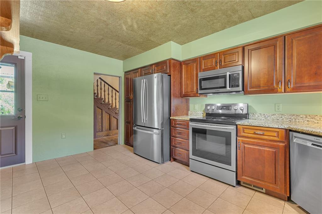 188 Logtown Road Darlington, PA 16115 - Photo 4 of 36 a kitchen with granite countertop a refrigerator and a stove top oven
