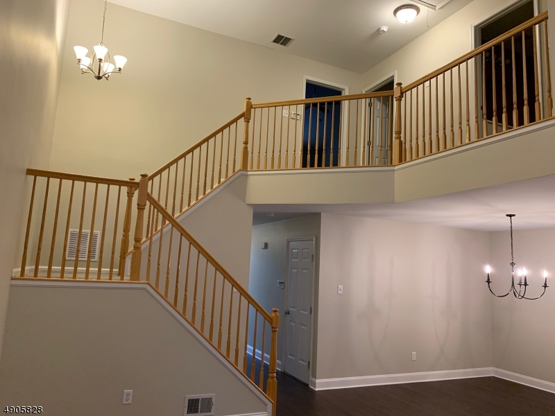 105 Well Sweep Road, Unit 105 Whitehouse Station, NJ 08889 - Photo 8 of 22 a view of staircase with lots of frames on wall and wooden floor