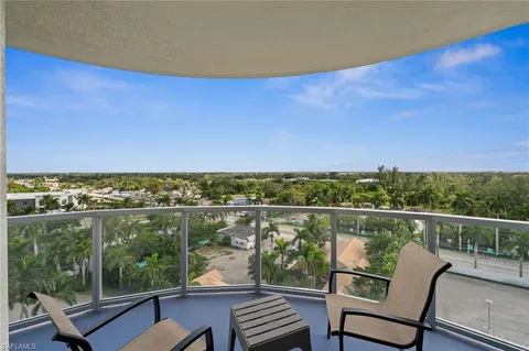 a view of a city from a balcony with furniture