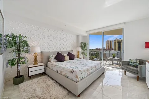 a bedroom with a large bed and a potted plant
