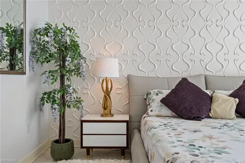 a bed sitting in a bedroom and potted plant
