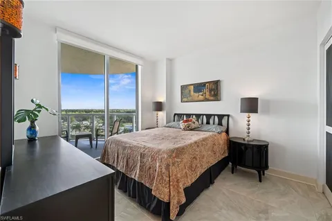 a bedroom with a bed and a dresser next to a window