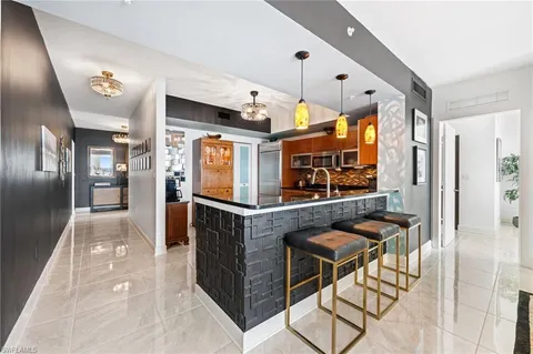 a kitchen with stainless steel appliances kitchen island granite countertop a refrigerator and a stove