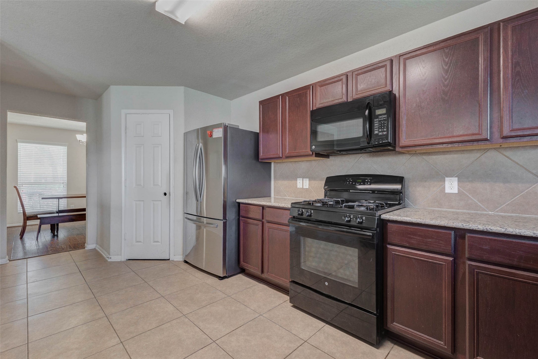 3027 Upland Spring Trace Katy, TX 77493 - Photo 8 of 29 a kitchen with stainless steel appliances granite countertop a stove a refrigerator and a microwave