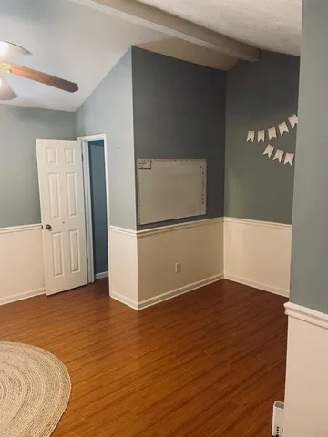an empty room with wooden floor and cabinet