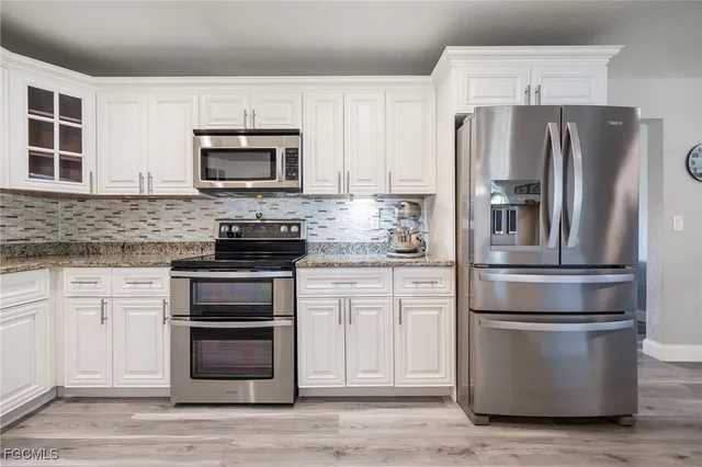 a kitchen with stainless steel appliances granite countertop a refrigerator stove and microwave