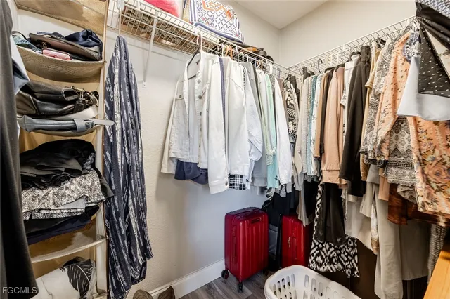 a view of walk in closet with clothes and shoes