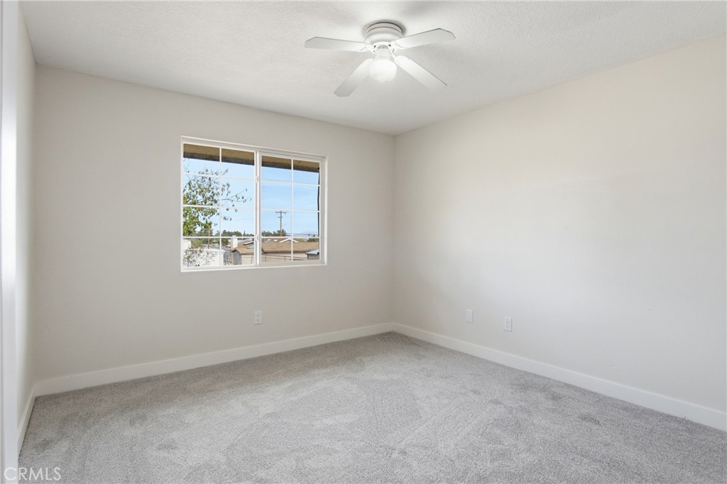 17964 Hackberry Street Hesperia, CA 92345 - Photo 11 of 32 an empty room with a window and ceiling fan