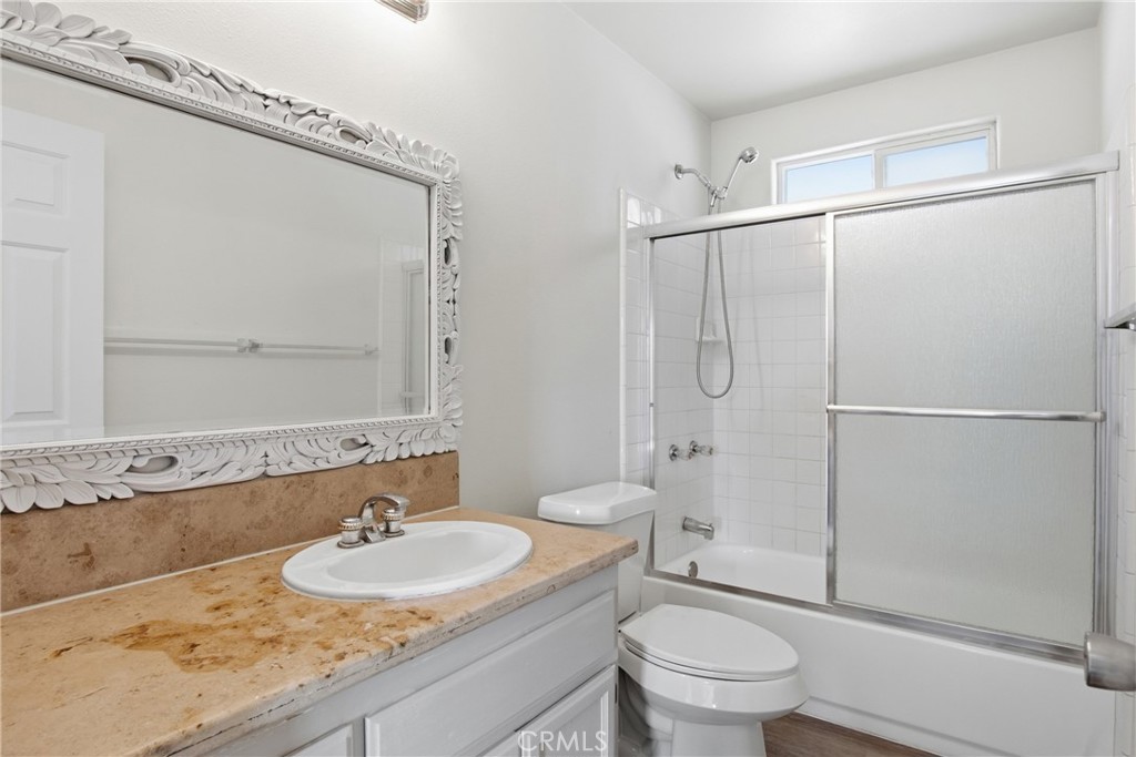 17964 Hackberry Street Hesperia, CA 92345 - Photo 13 of 32 a bathroom with a granite countertop sink toilet a mirror and shower