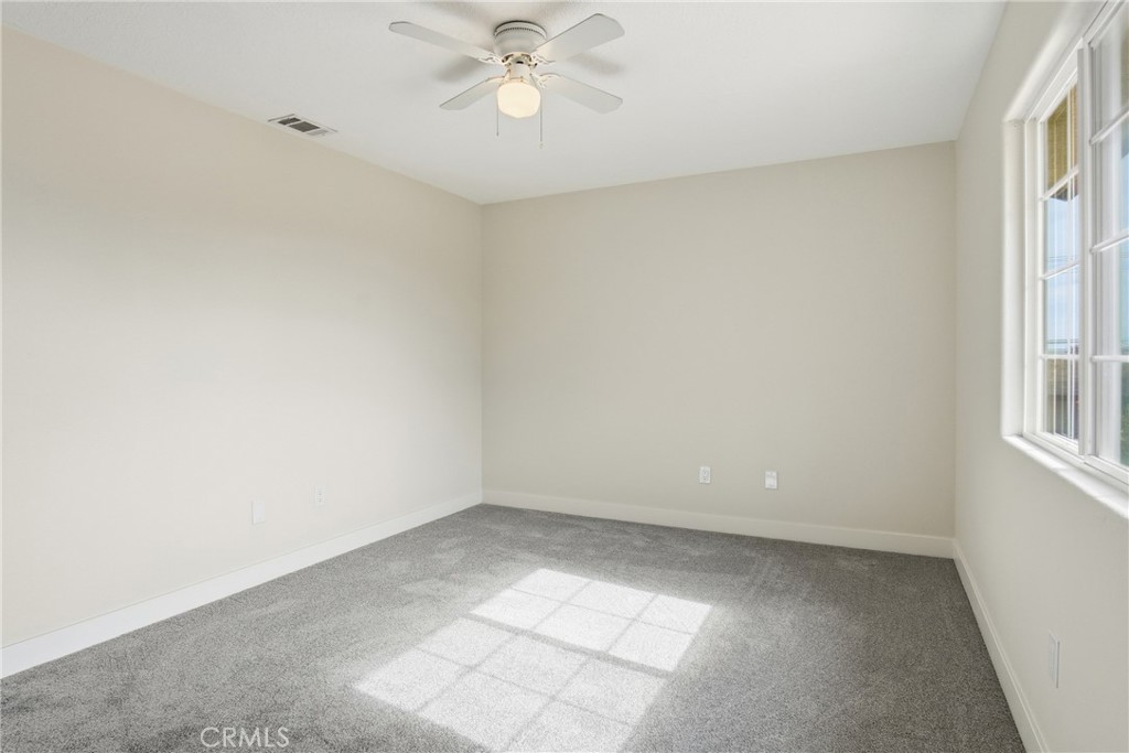 17964 Hackberry Street Hesperia, CA 92345 - Photo 9 of 32 an empty room with windows and fan
