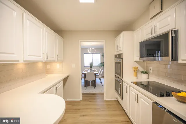 a view of a kitchen with a sink wooden cabinets and a window