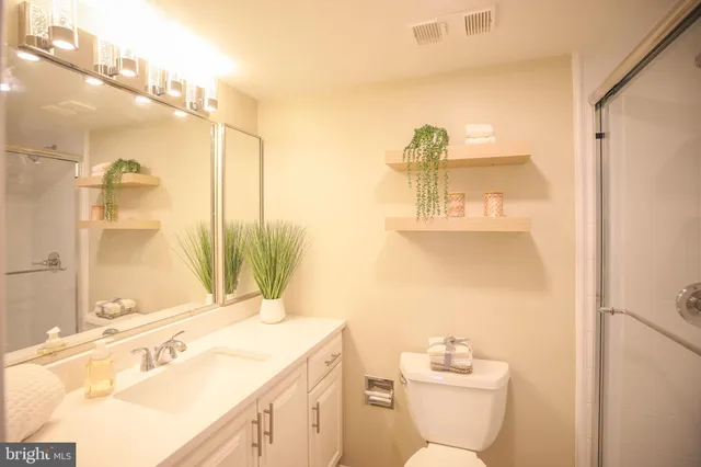 a bathroom with a sink vanity granite and toilet