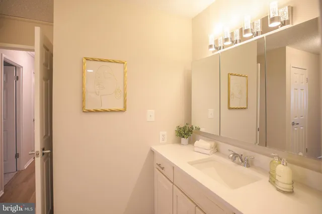 a bathroom with a granite countertop sink and a mirror