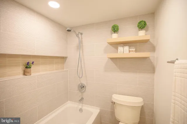 a bathroom with a bathtub shower sink vanity and toilet