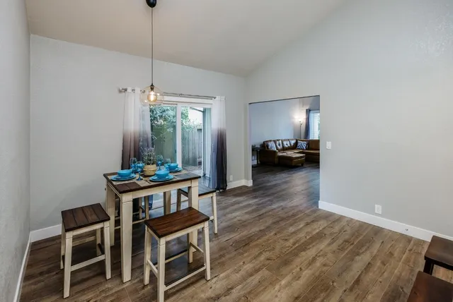 a kitchen with stainless steel appliances granite countertop a table chairs refrigerator and microwave