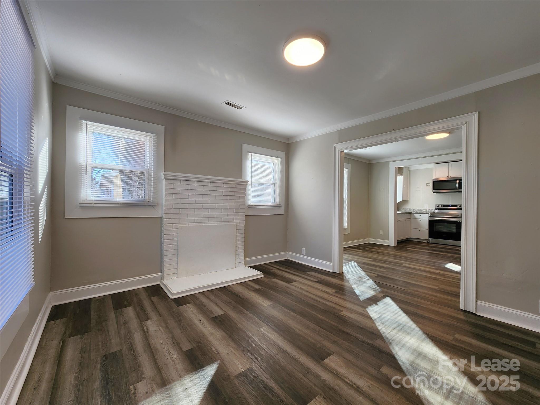 2802 Maryland Avenue Kannapolis, NC 28083 - Photo 2 of 19 an empty room with wooden floor and windows
