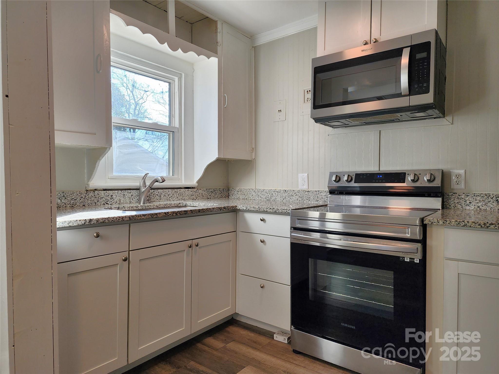 2802 Maryland Avenue Kannapolis, NC 28083 - Photo 4 of 19 a kitchen with stainless steel appliances a stove a microwave a sink and cabinets
