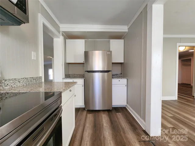 a view of a kitchen with a stove wooden floor and a kitchen space