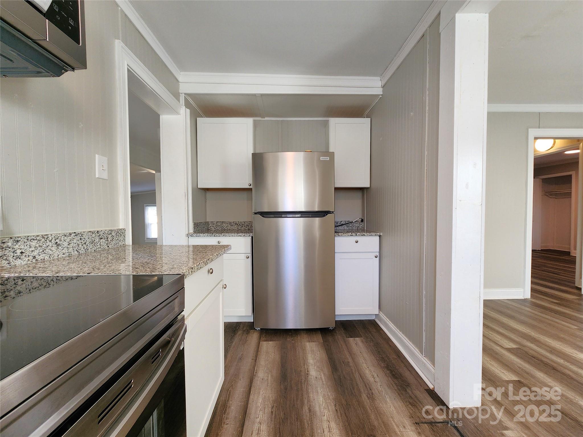2802 Maryland Avenue Kannapolis, NC 28083 - Photo 5 of 19 a view of a kitchen with a stove wooden floor and a kitchen space