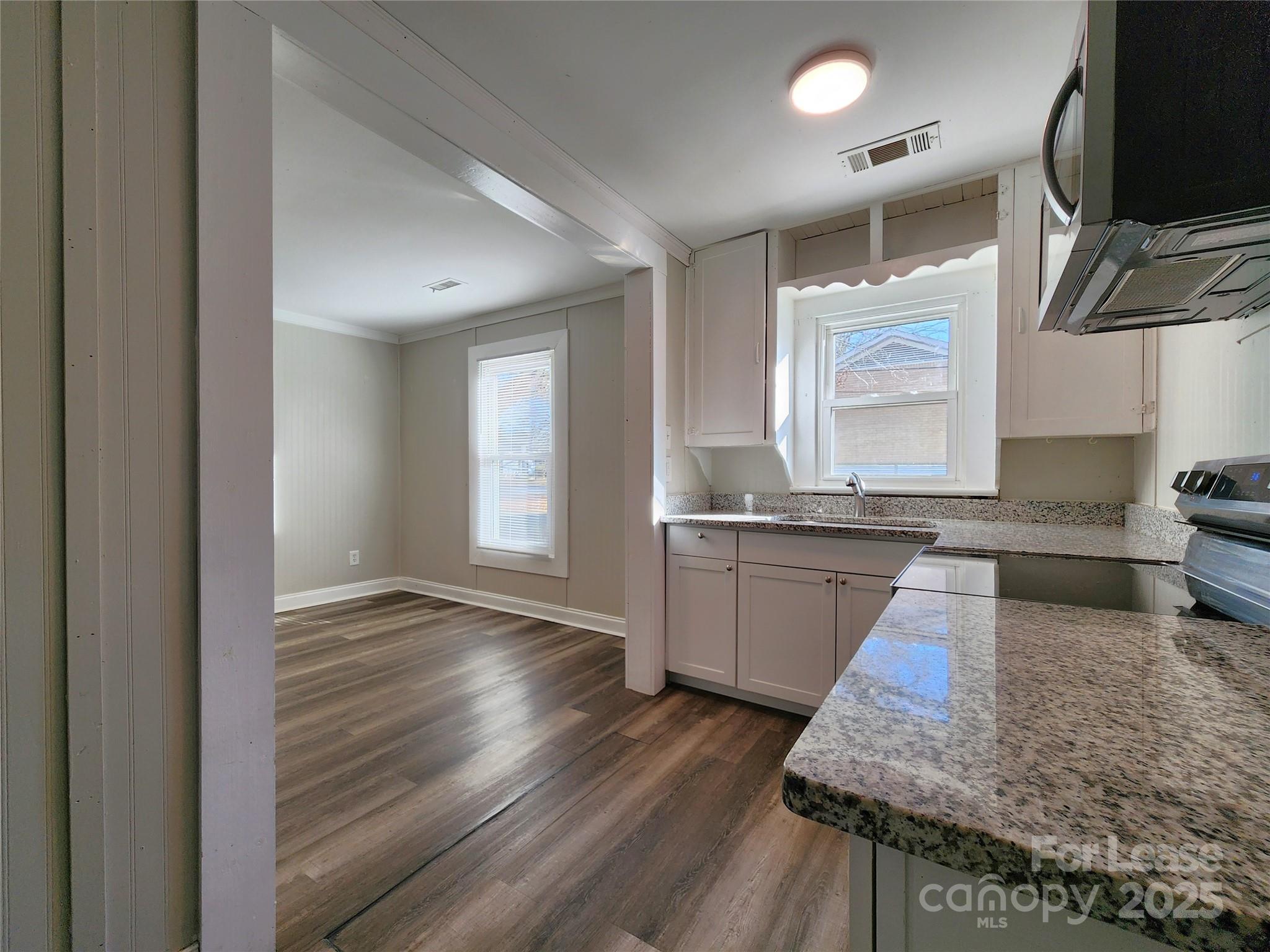 2802 Maryland Avenue Kannapolis, NC 28083 - Photo 7 of 19 a kitchen with granite countertop wooden floors and stainless steel appliances