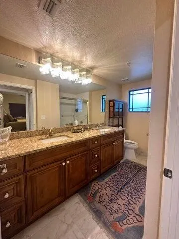 a spacious bathroom with a granite countertop sink and a mirror