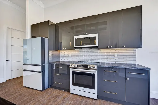 a kitchen with granite countertop cabinets stainless steel appliances and wooden floor