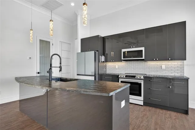 a kitchen with stainless steel appliances granite countertop a sink stove and refrigerator