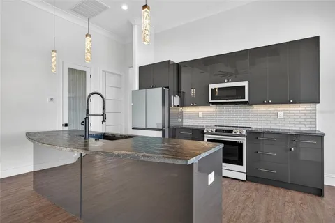 a kitchen with stainless steel appliances granite countertop a sink stove and refrigerator