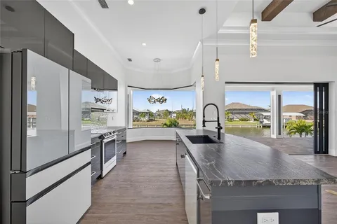 a kitchen with stainless steel appliances granite countertop a refrigerator a stove and a sink