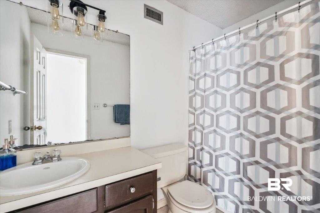 3616 Vista Ridge Drive Mobile, AL 36693 - Photo 15 of 20 Bathroom featuring a textured ceiling, toilet, and vanity