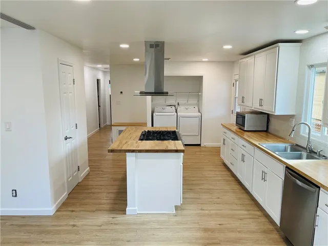 a large kitchen with stainless steel appliances granite countertop a stove and a sink