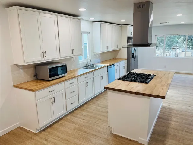 a kitchen with granite countertop white cabinets and white appliances