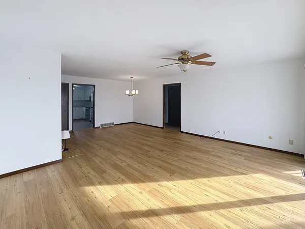 a view of an empty room with wooden floor
