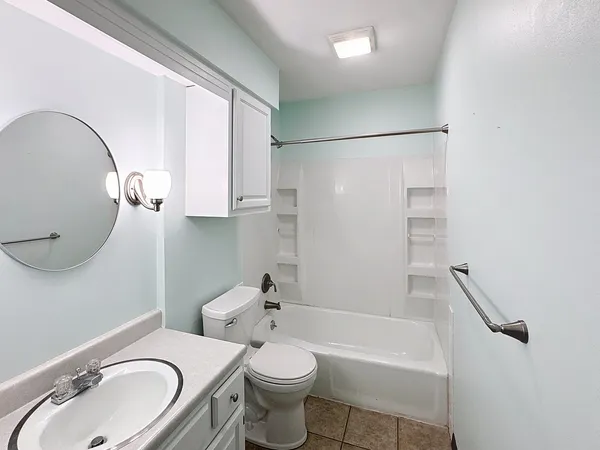 a bathroom with a granite countertop toilet sink and mirror