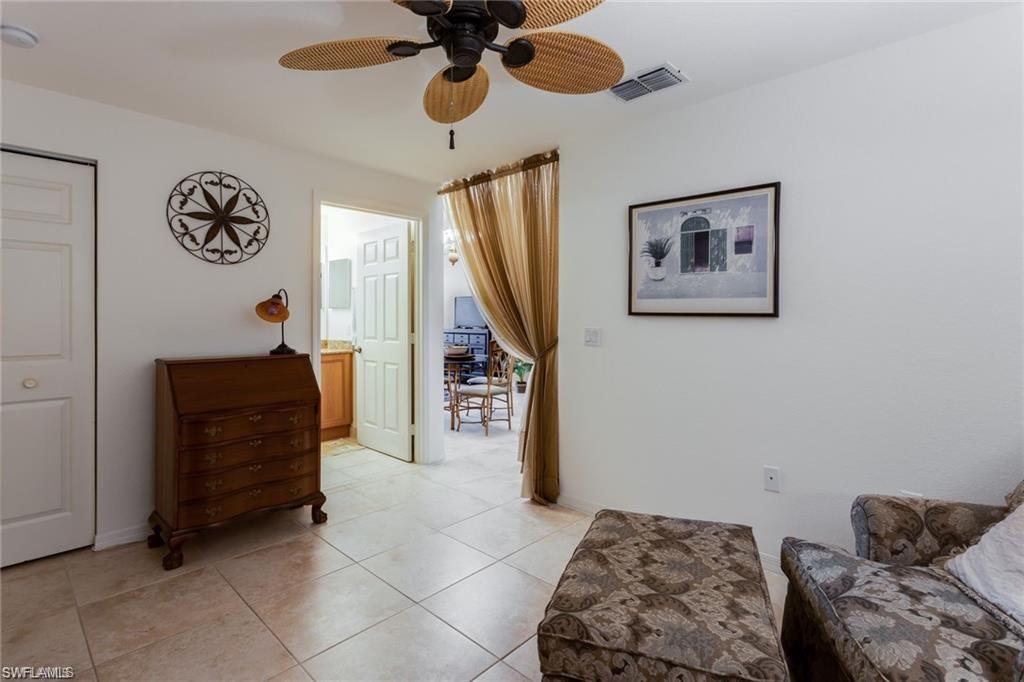20201 Estero Gardens Circle, Unit 104 Estero, FL 33928 - Photo 12 of 38 a bedroom with a bed and a chandelier