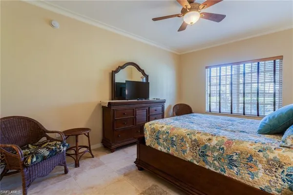 a bedroom with a bed and a dresser next to a window