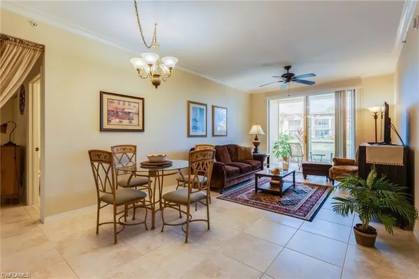 a living room with furniture a chandelier and a window