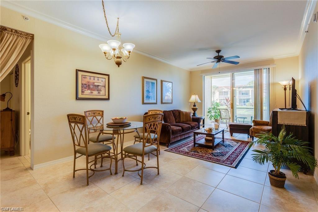 20201 Estero Gardens Circle, Unit 104 Estero, FL 33928 - Photo 4 of 38 a living room with furniture a chandelier and a window