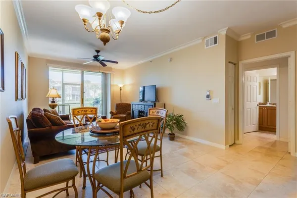 a dining room with furniture a chandelier and window