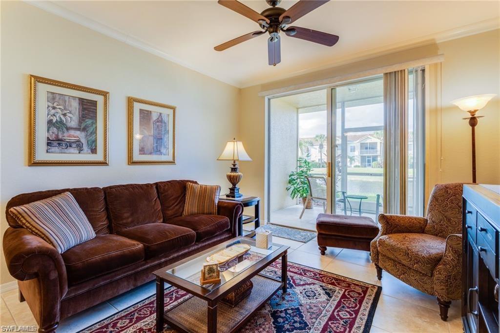 20201 Estero Gardens Circle, Unit 104 Estero, FL 33928 - Photo 6 of 38 a living room with furniture a large window and a flat screen tv