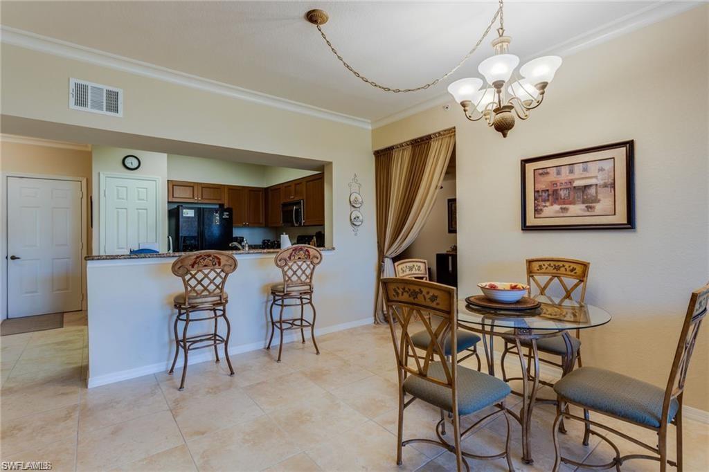 20201 Estero Gardens Circle, Unit 104 Estero, FL 33928 - Photo 10 of 38 a view of a dining room with furniture and chandelier