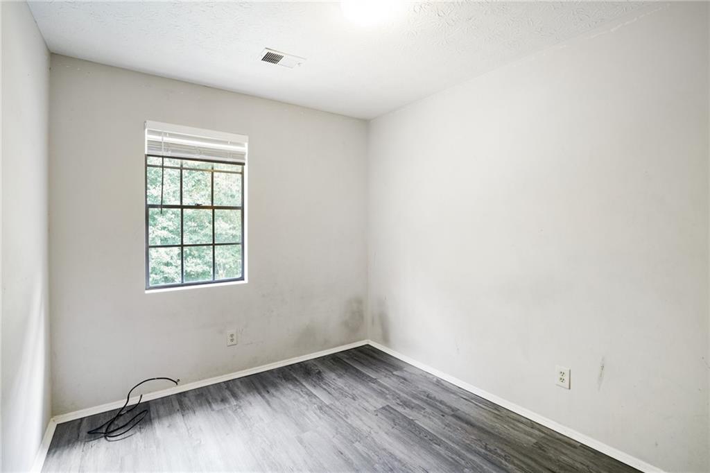 1608 Pine Tree Trail Atlanta, GA 30349 - Photo 12 of 17 an empty room with wooden floor and windows