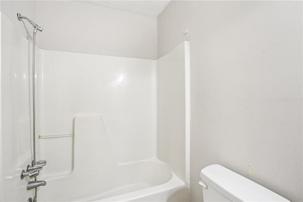 1608 Pine Tree Trail Atlanta, GA 30349 - Photo 13 of 17 a bathroom with a bathtub and toilet