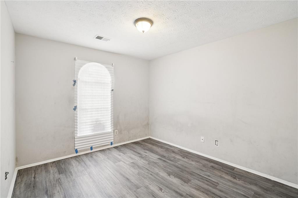 1608 Pine Tree Trail Atlanta, GA 30349 - Photo 14 of 17 an empty room with wooden floor and windows