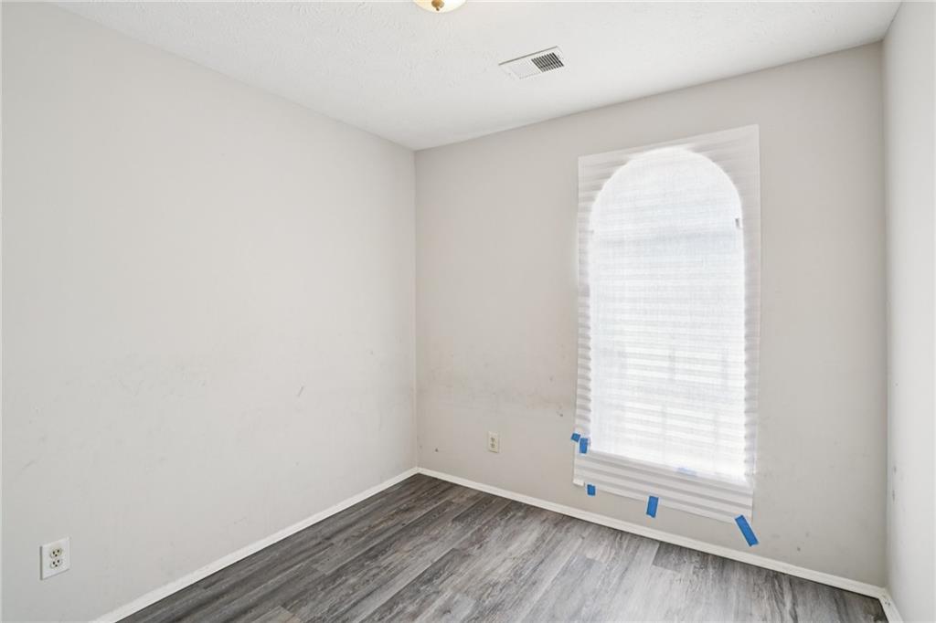 1608 Pine Tree Trail Atlanta, GA 30349 - Photo 15 of 17 an empty room with wooden floor and windows