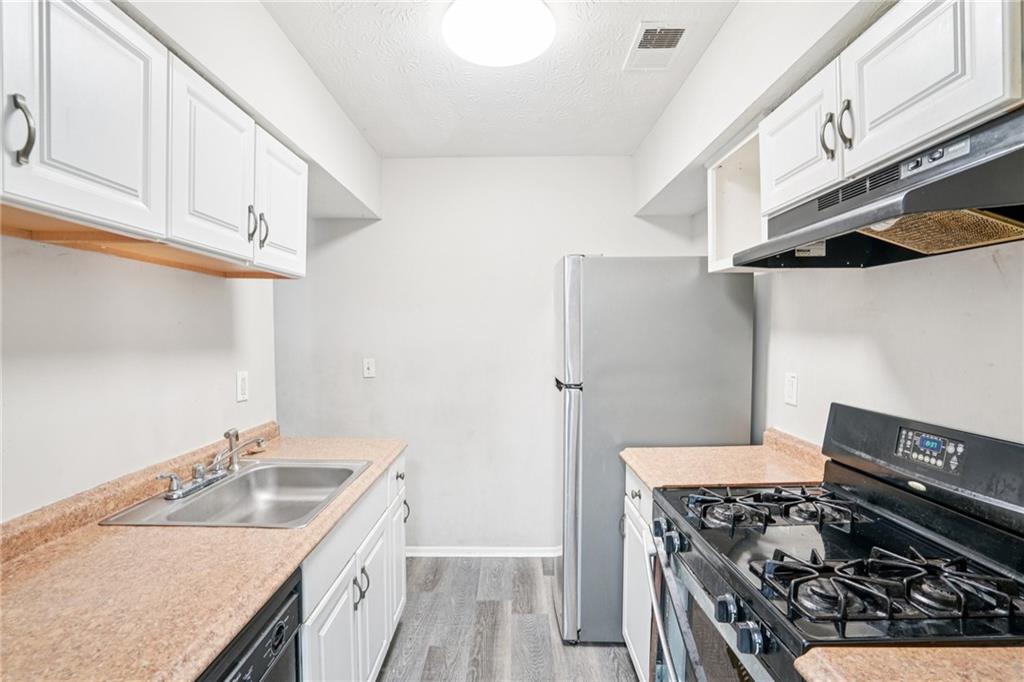 1608 Pine Tree Trail Atlanta, GA 30349 - Photo 7 of 17 a kitchen with a stove and a sink